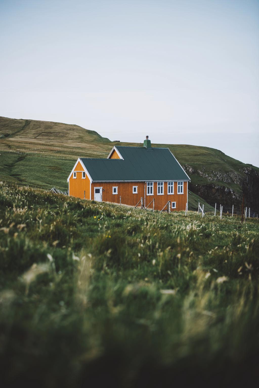 A yellow house in nature on the islands, Suðuroy, Faroe Islands.